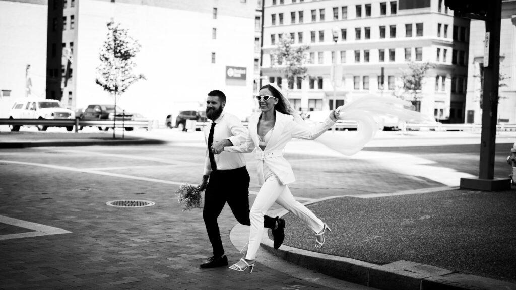 Bride and Groom Running in Downtown Pittsburgh after elopement in the Allegheny County Courthouse