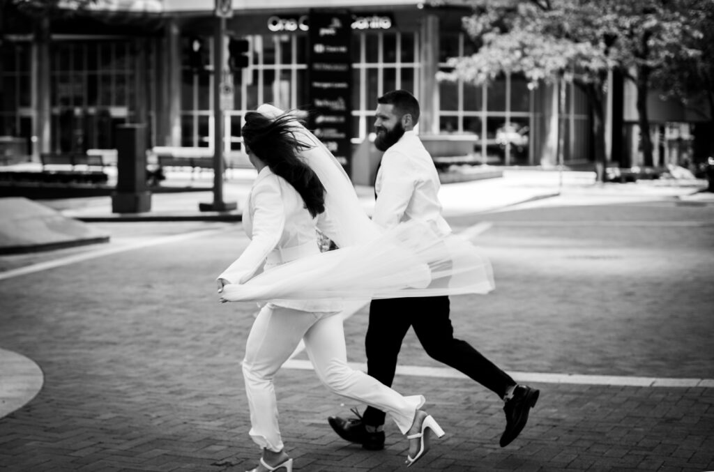 Bride and Groom Running in Pittsburgh Downtown after elopement in the Allegheny County Courthouse - Perfect Wedding dress