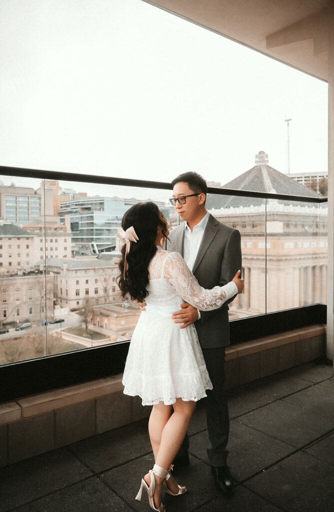 Couple Stand in the patio of the Oaklander Hotel in Pittsburgh overlooking Oakland