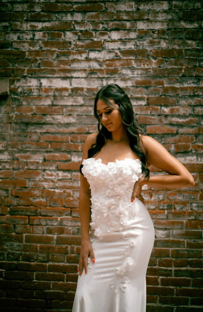 Bride looking down wearing her wedding gown.