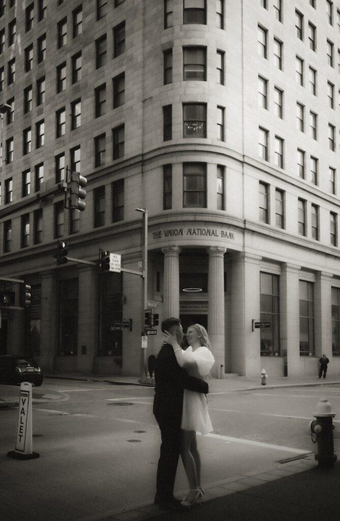 Couple Standing looking at each other in front of bank in Downtown Pittsburgh