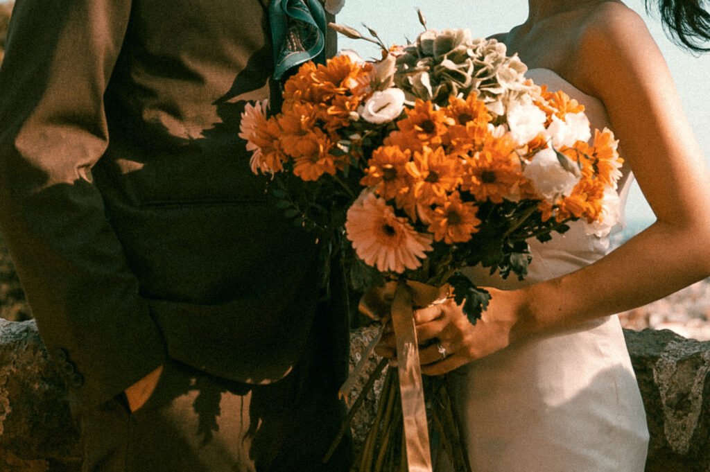 Groom and Bride holding Bouquet in wedding attire at Park Guell