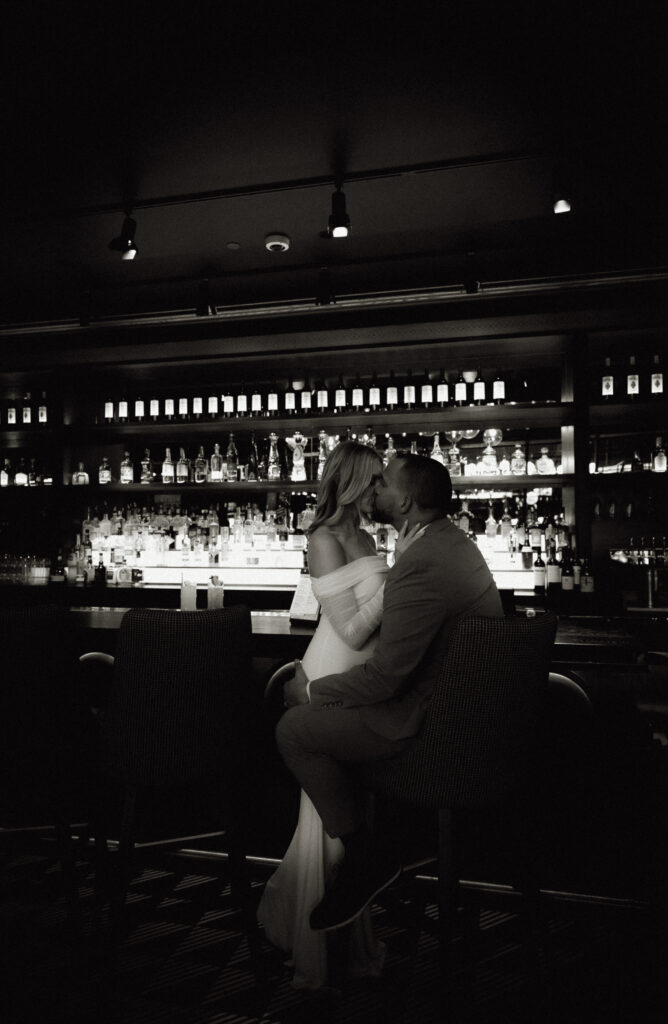 Sexy Bride and Groom kissing at the bar of Puttshack in Pittsburgh