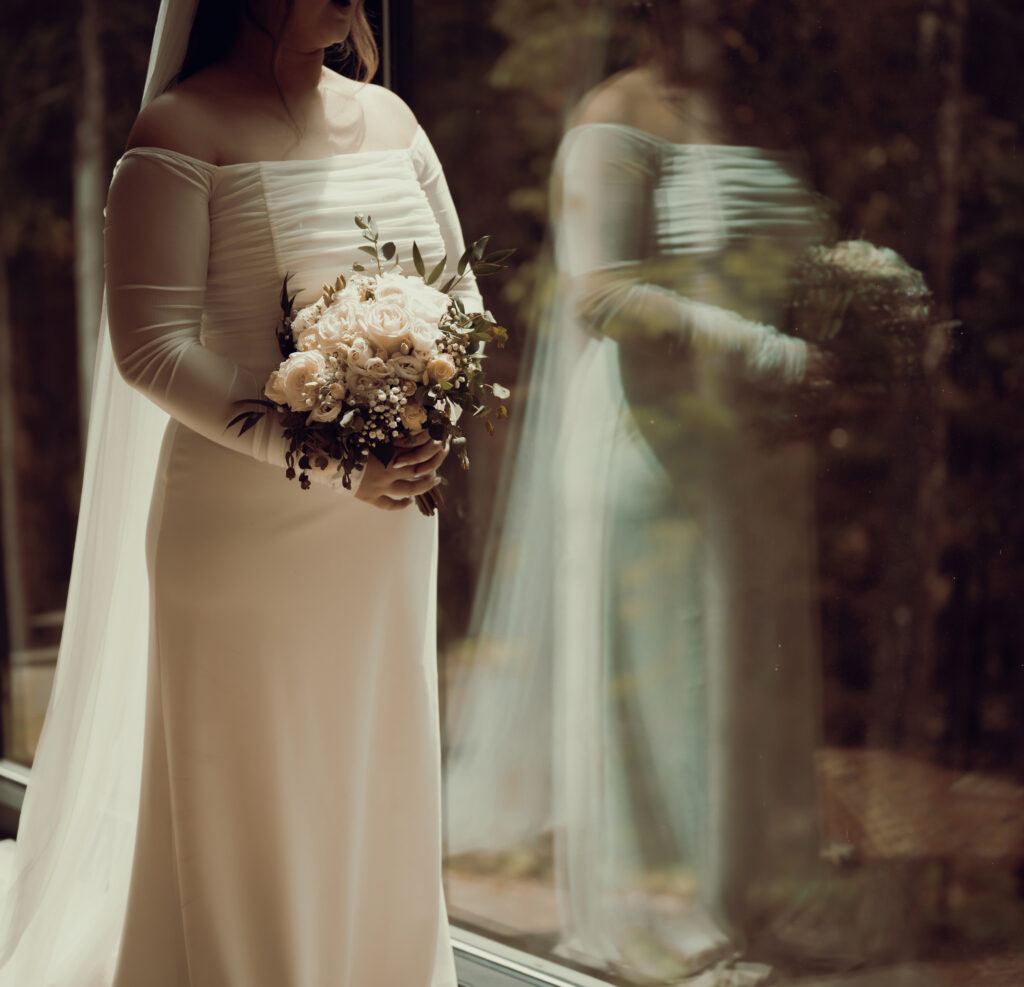 Bride standing at Bride and Groom standing with umbrellas and an officiant at Pittsburgh Botanic Garden Store