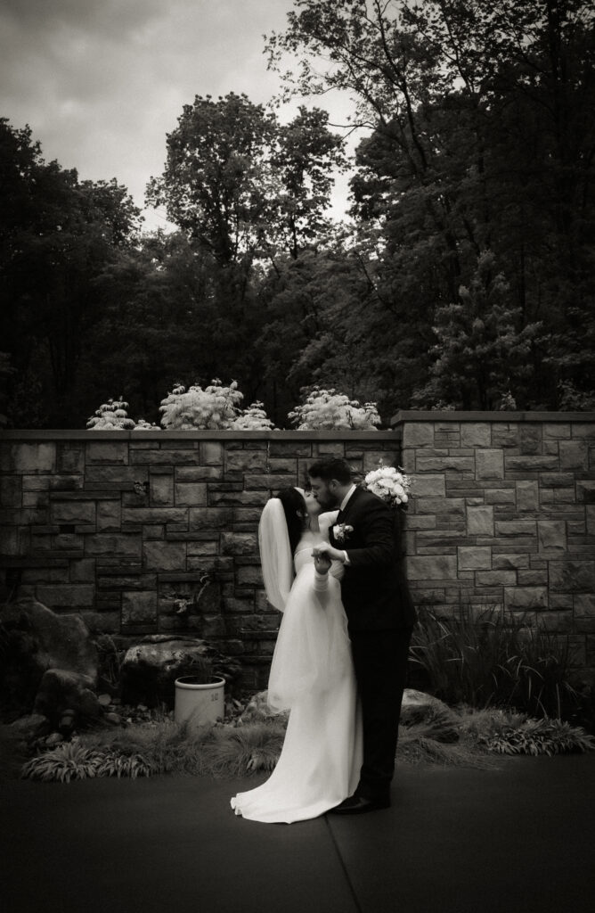 Bride and Groom kissing at Bride and Groom standing with umbrellas and an officiant at Pittsburgh Botanic Garden