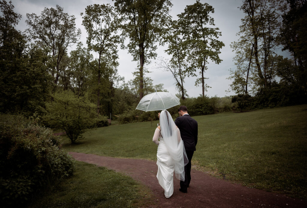 Bride and Groom walking away at Bride and Groom standing with umbrellas and an officiant at Pittsburgh Botanic Garden