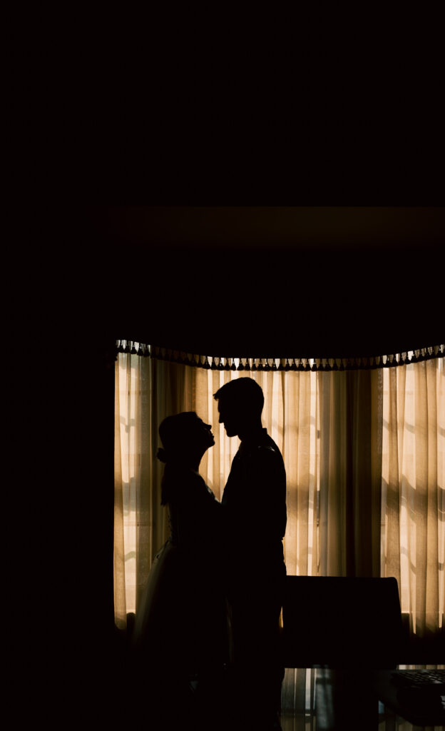 Bride and Groom silhouette facing each other at the library of Mansion On Fifth