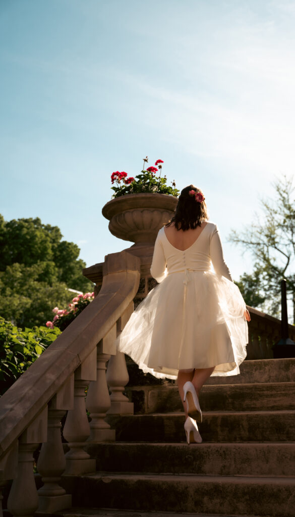 Bride going up the stairs of Mansion On Fifth Luxury Hotel during the afternoon with a blue sky