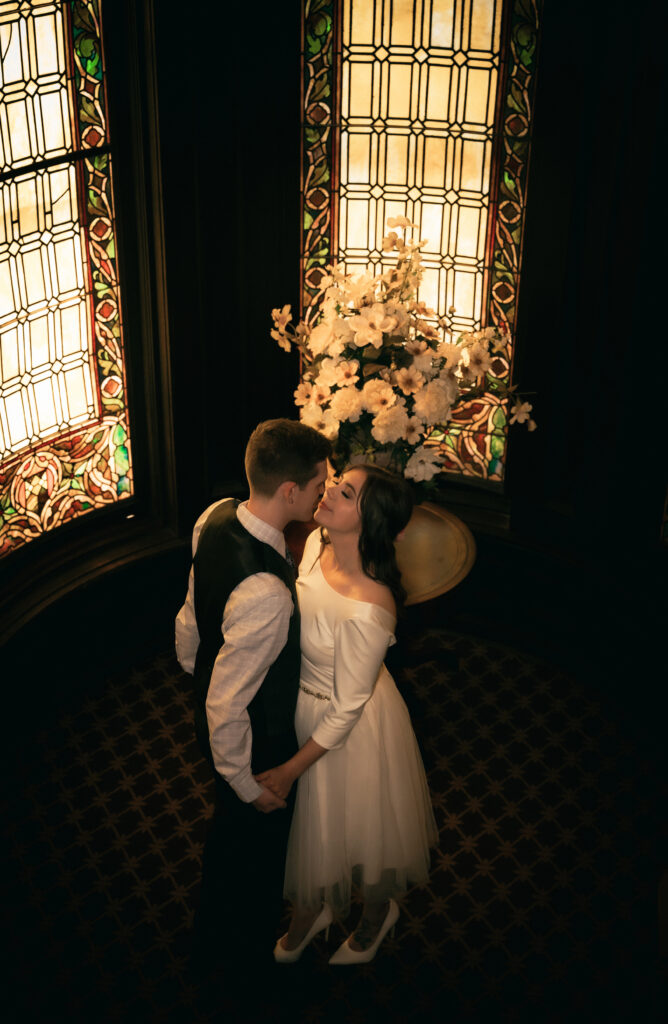 Bride and Groom about to kiss at the staircase of Mansion On Fifth Luxury Hotel after their wedding ceremony