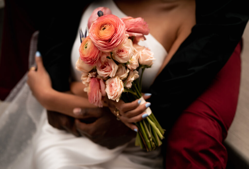 Bride and Groom Arms embracing each other and holding wedding bouquet