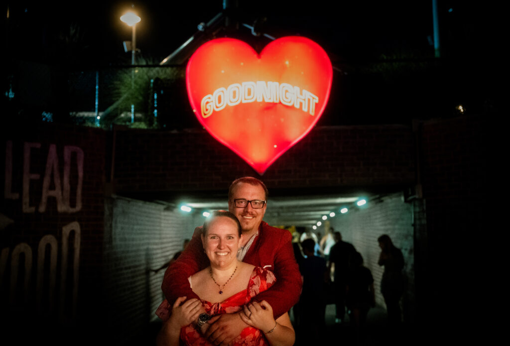 Couple stand in front of the Goodnight heart at the exit of Kennywood