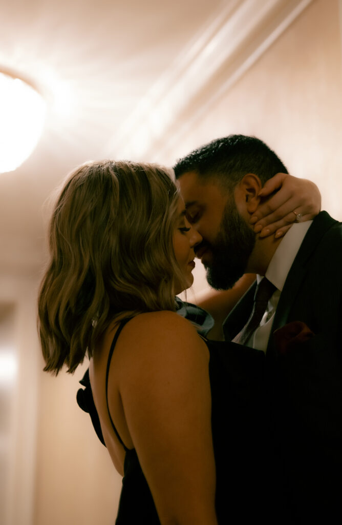 Couple about to kiss in a hotel hallway.
