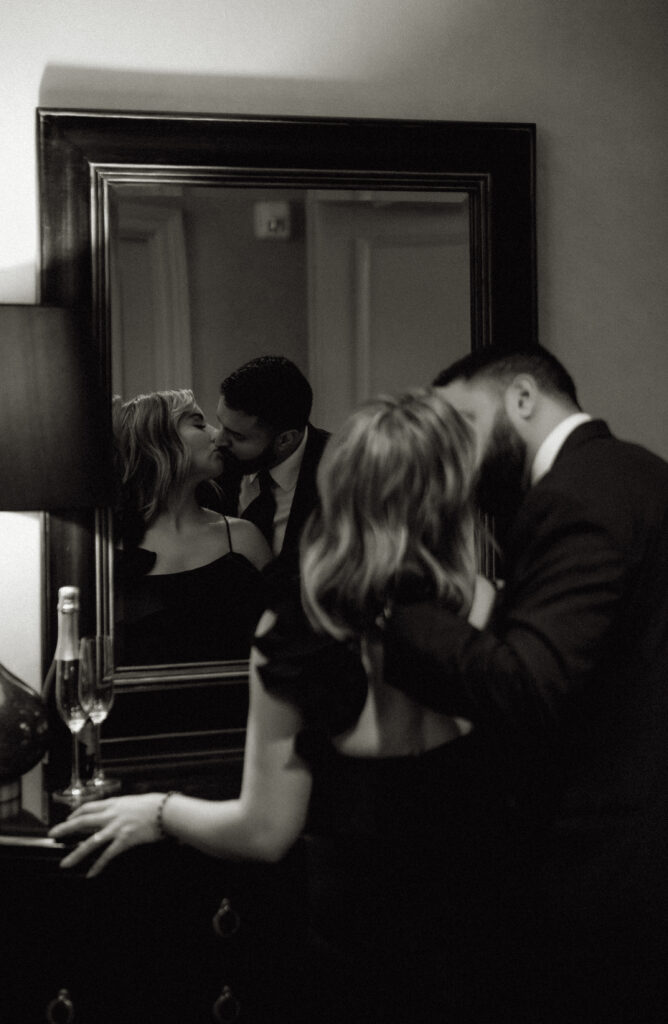 Couple kiss in front of the mirror of the Penn Hotel