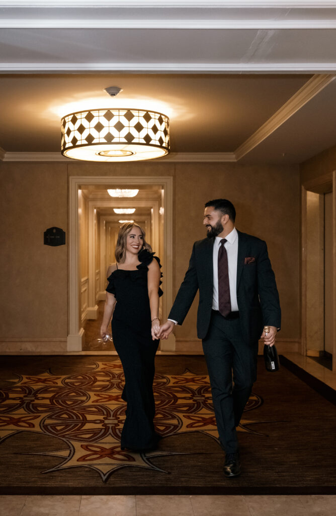 Couple look at each other as they walk holding hands in the Hallway of the Omni William Penn Hotel in Downtown Pittsburgh