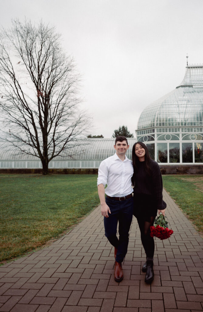 Couple smiling as they walk at one of Phipps Conservatory and Botanical Gardens entryways.