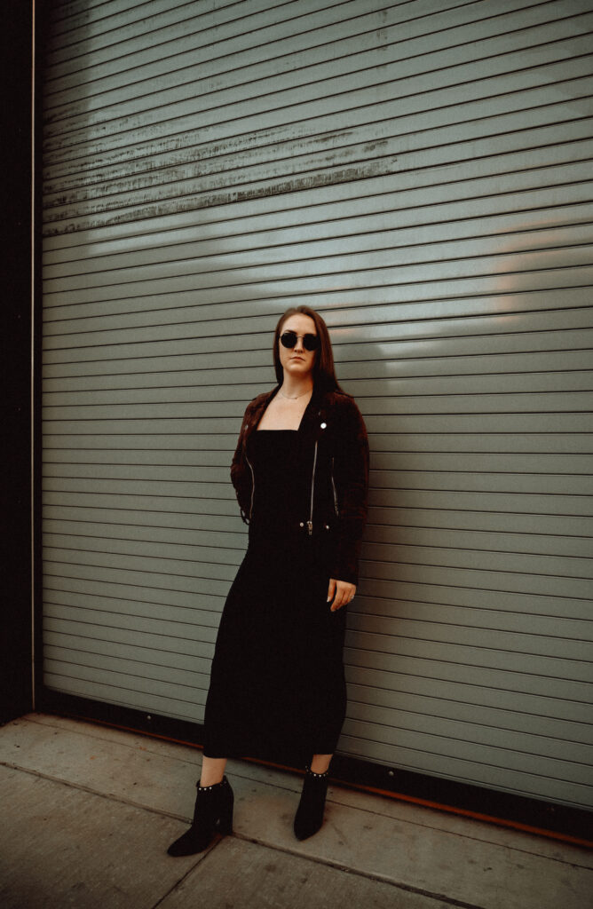 Woman wearing a black long dress with a leather jacket in the strip district