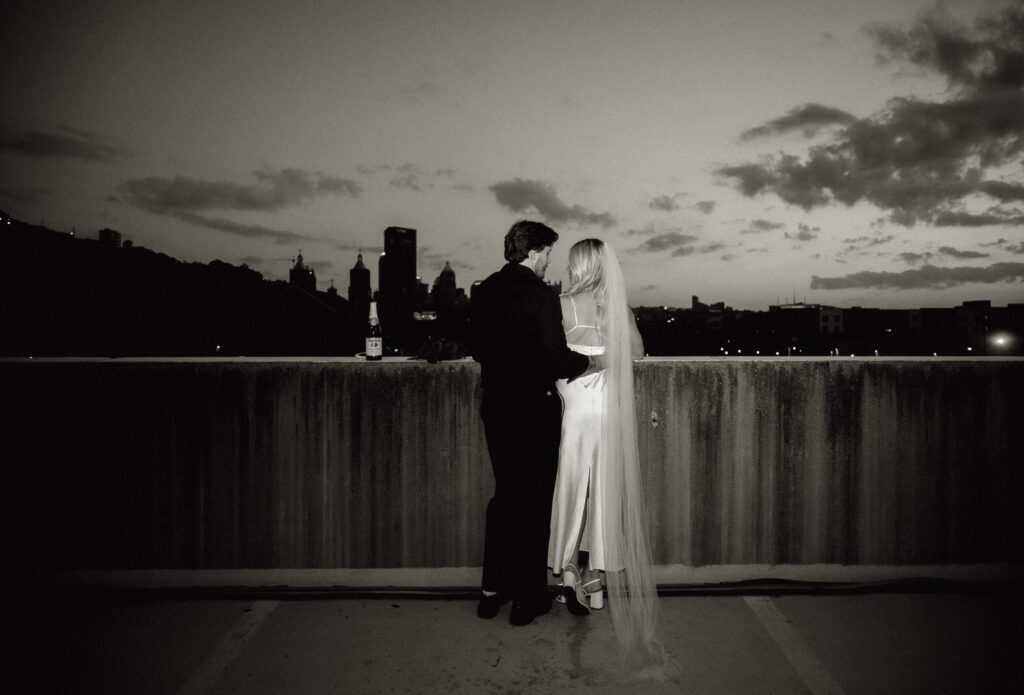 Couple kissing in rooftop overlooking Pittsburgh