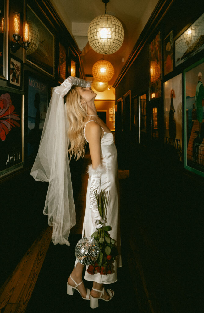 Bride holding bouquet or red roses at Row House Cinema in Pittsburgh