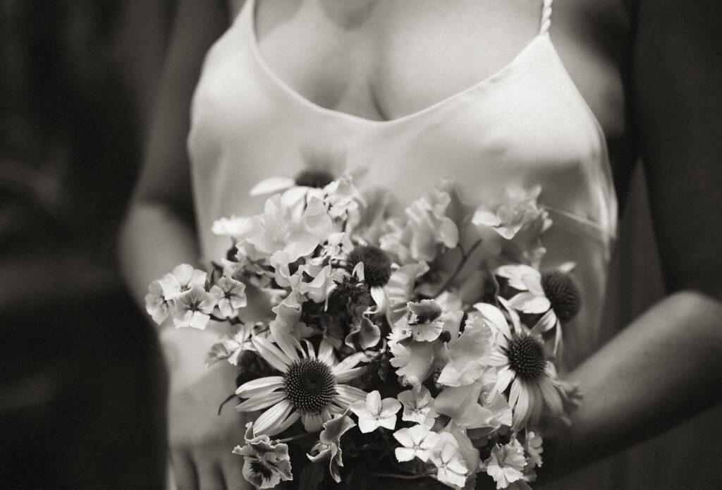 Boudoir Woman holding a bridal bouquet showing with nipples under her dress