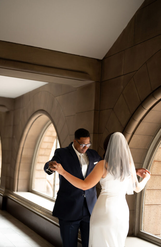 Groom sees bride for first time during their first look at the Allegheny Courthouse