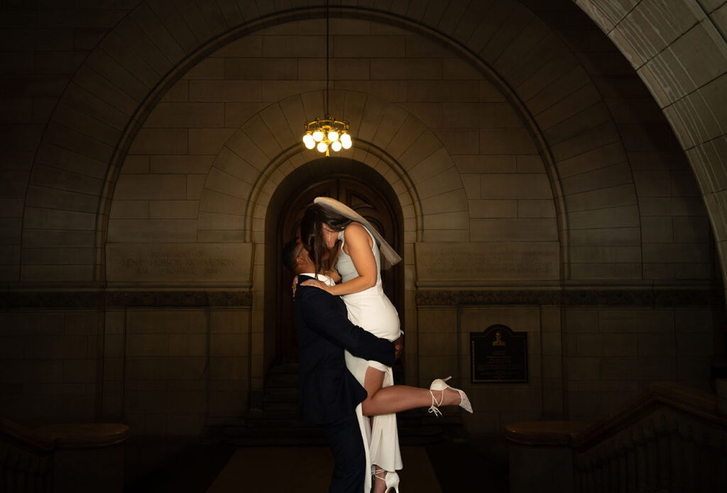 Groom lifts bride at the Allegheny Courthouse after their intimate wedding