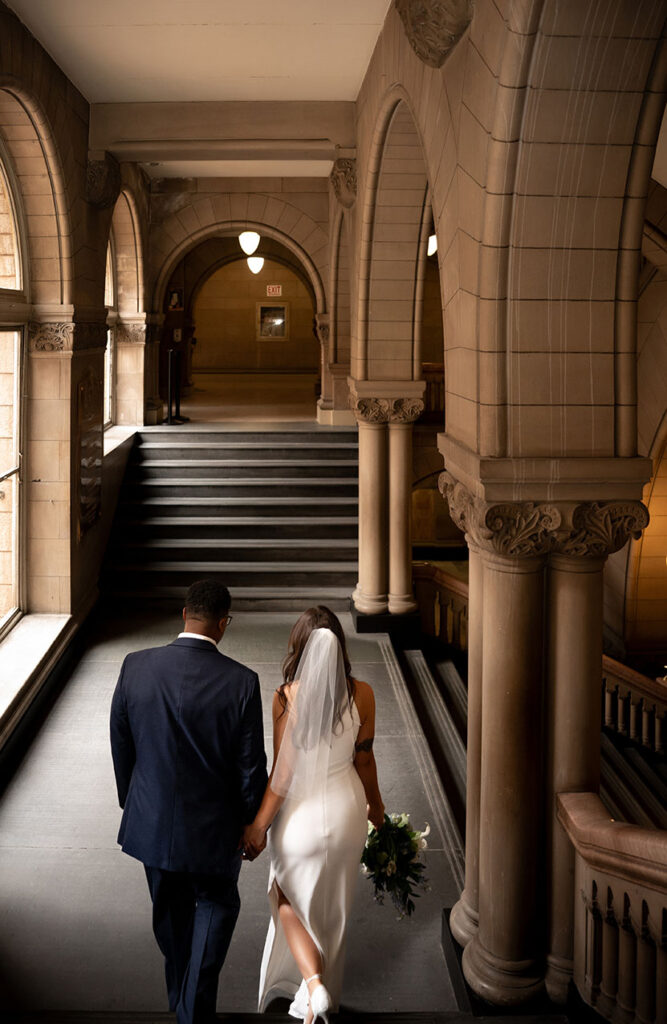 Bride and Groom walking down the staircase of the Allegheny Courthouse after their wedding in Downtown Pittsburgh