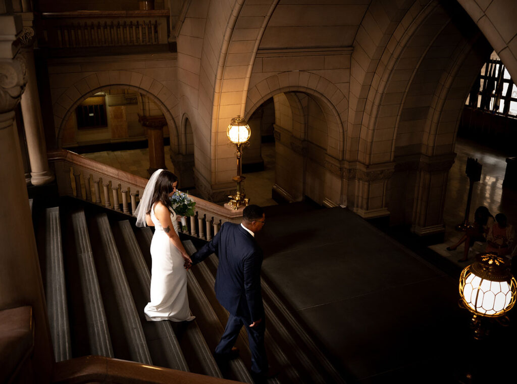 Bride and Groom walking down the staircase of the Allegheny Courthouse after their wedding in Downtown Pittsburgh
