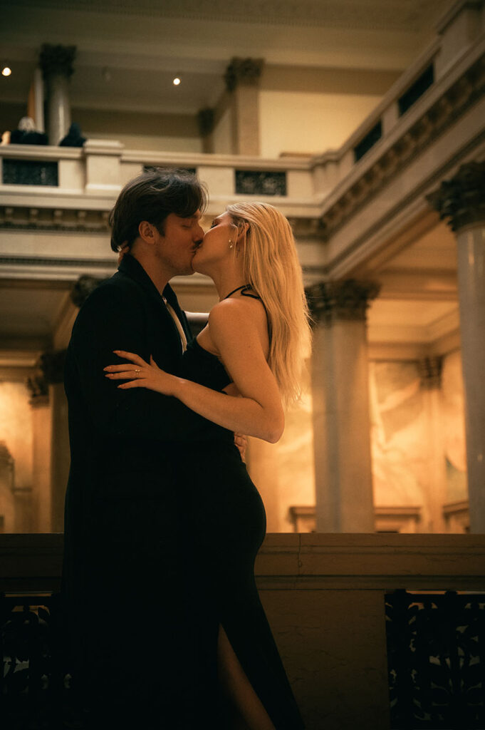Couple kiss at Carnegie Museum of Art in Pittsburgh celebrating their engagement