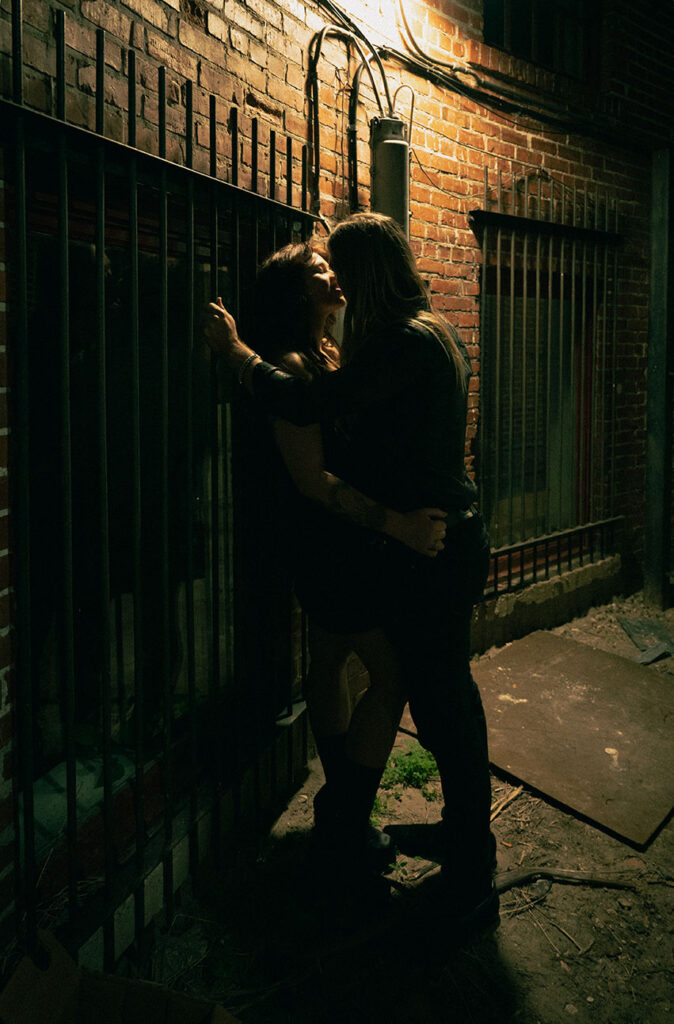 Couple kissing in an alley during their engagement