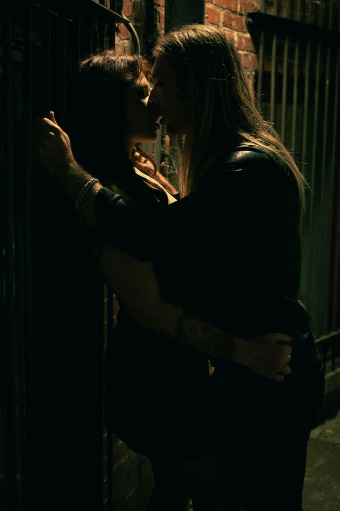 Couple kissing in an alley during their engagement