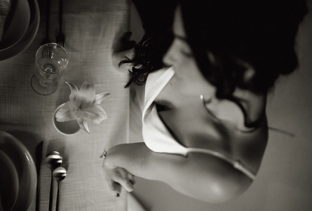 BW Bride Stands in front of Wedding Table Decor with flowers