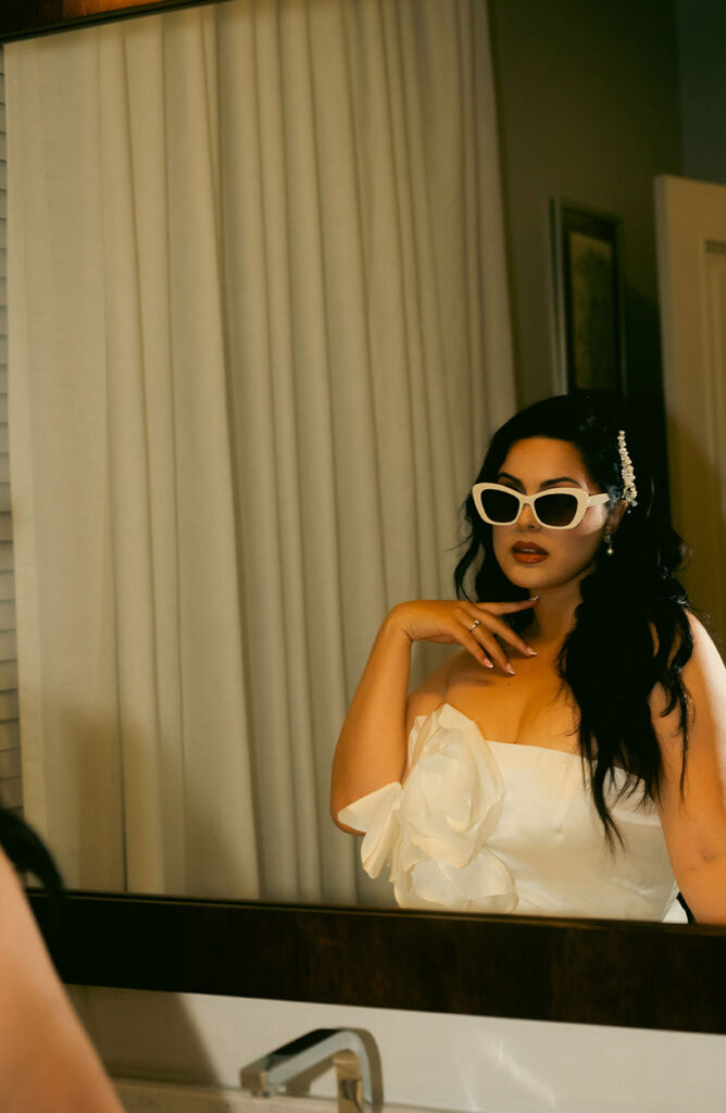 Bride looking in the mirror after getting ready at South Florida Hotel Bathroom