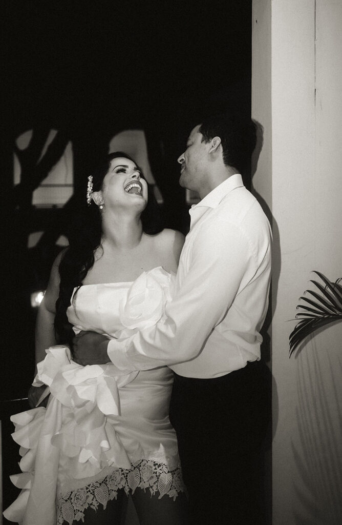 Bride laughs as groom embraces her during engagement session in Miami