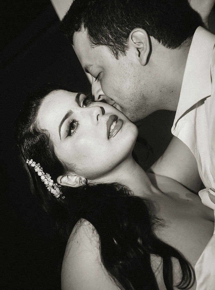 BW Bride looking away as Groom kisses her cheek