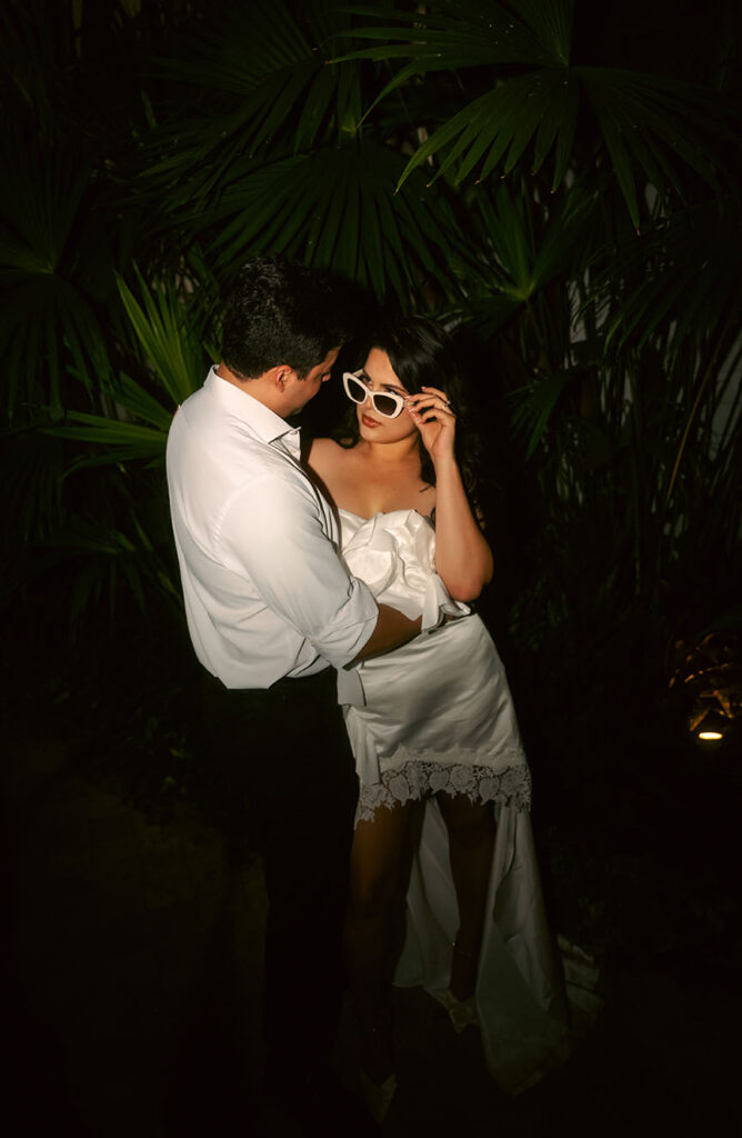 Couple standing in front of palm tree during their engagement in Miami