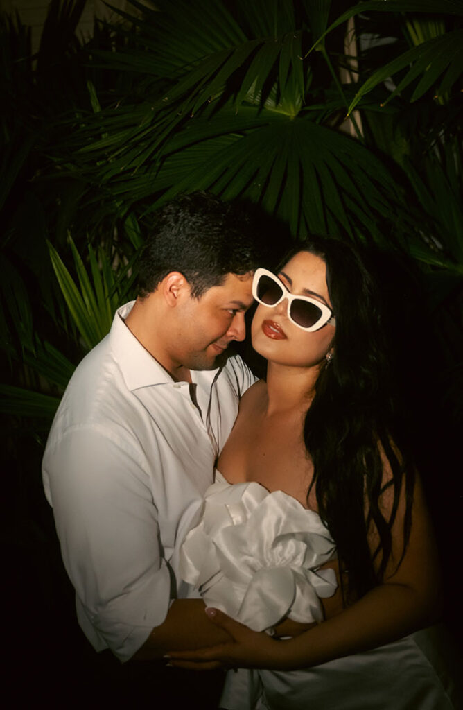 Couple standing in front of palm tree during their engagement in Miami