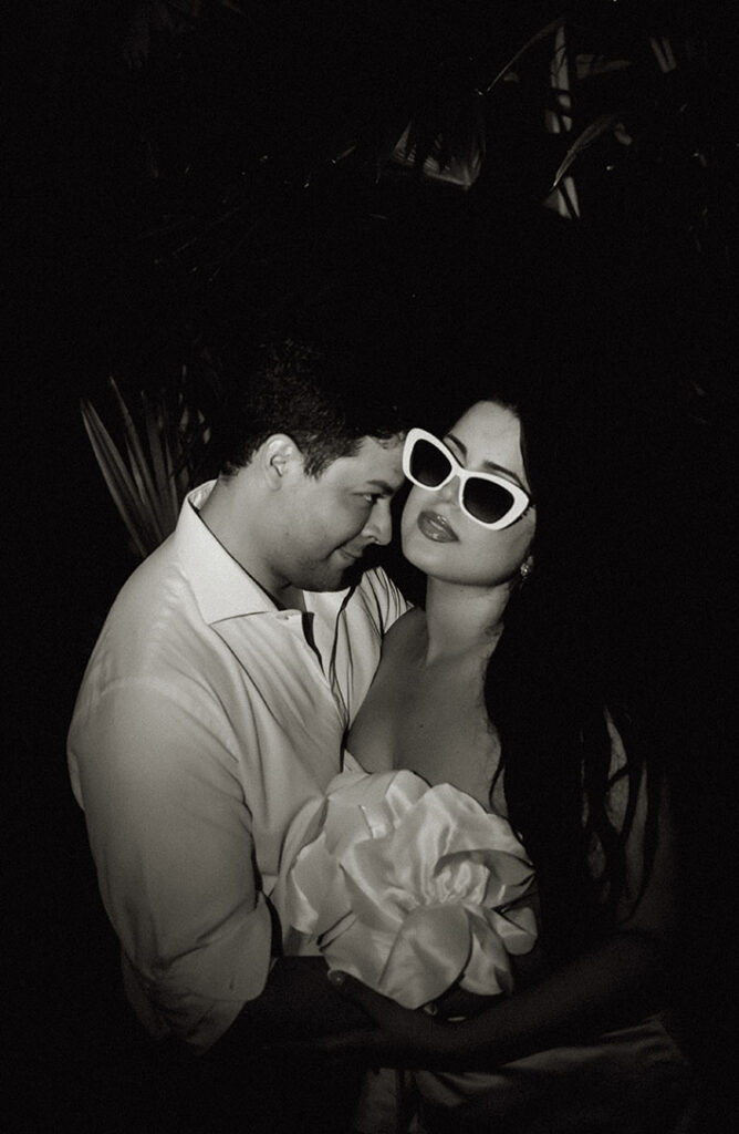 Couple standing in front of palm tree during their engagement in Miami