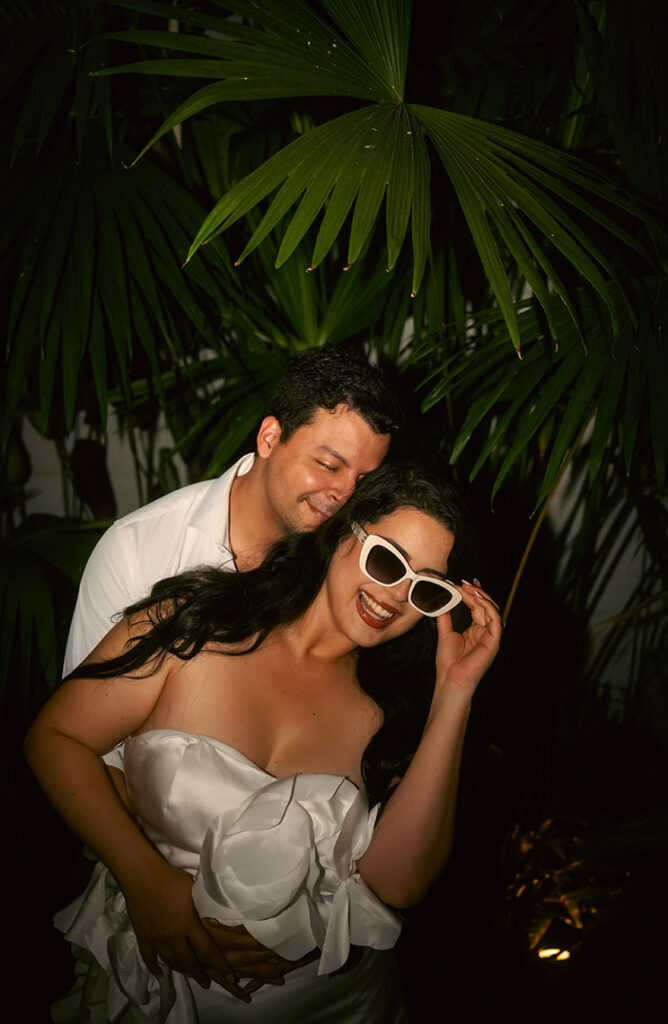 Couple standing in front of palm tree during their engagement in Miami