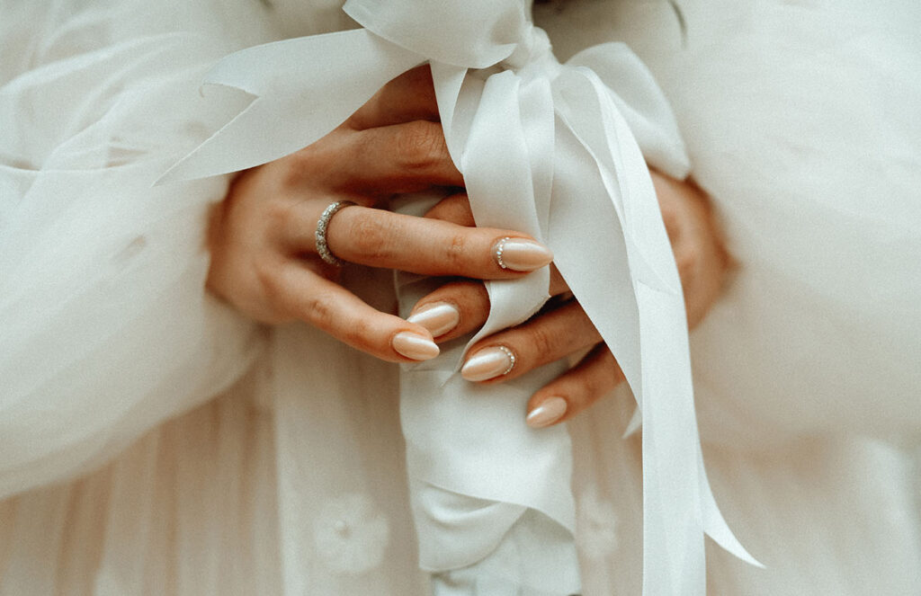 Bride holding bouquet showing off her nails