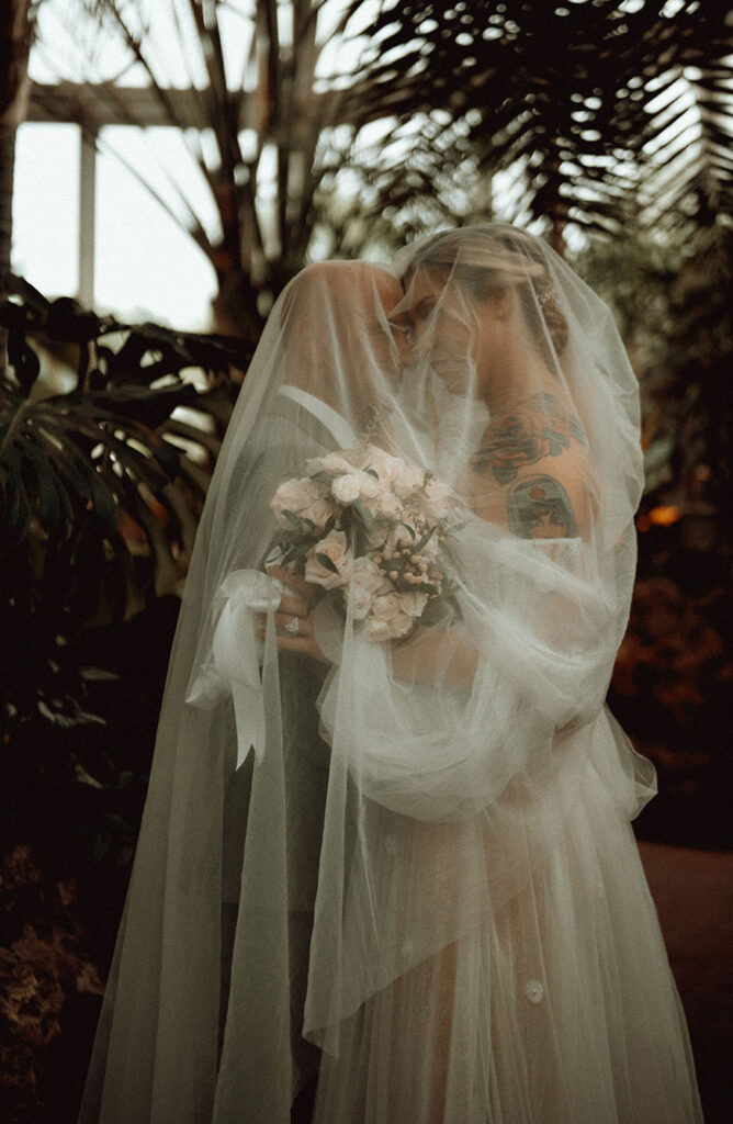 Bride and Groom under veil at Phipps Conservatory and Botanical Gardens