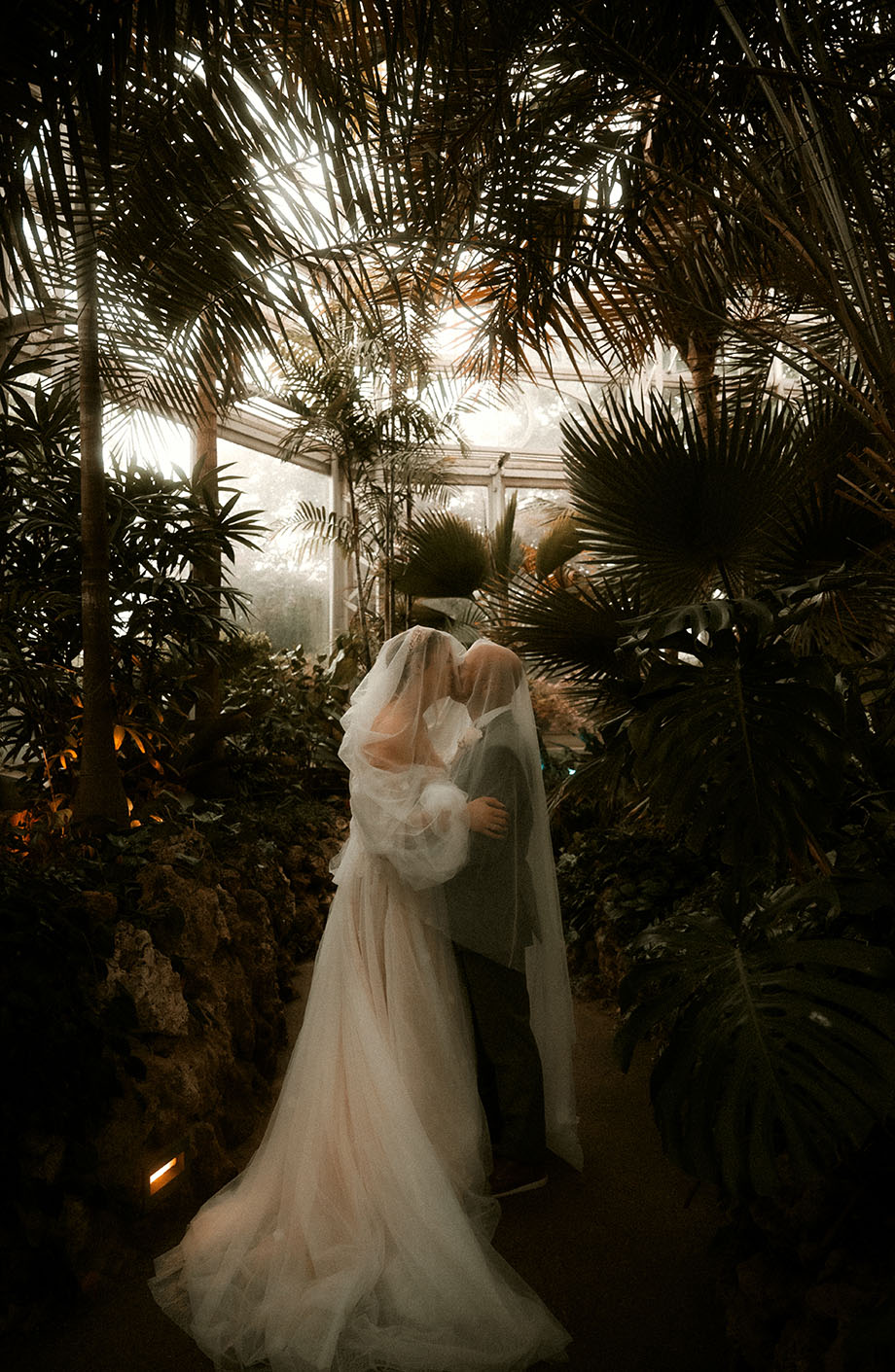 Bride and Groom Kiss under wedding veil at each other at Phipps Conservatory and Botanical Gardens