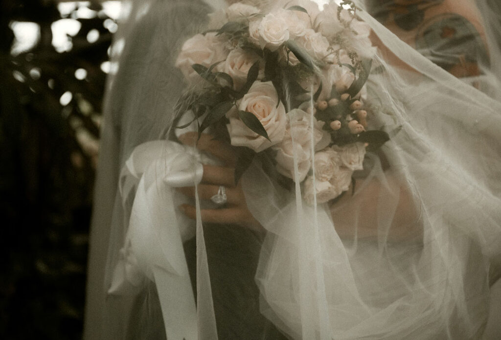 Bride and Groom hold each other with engagement ring in focus at Phipps Conservatory