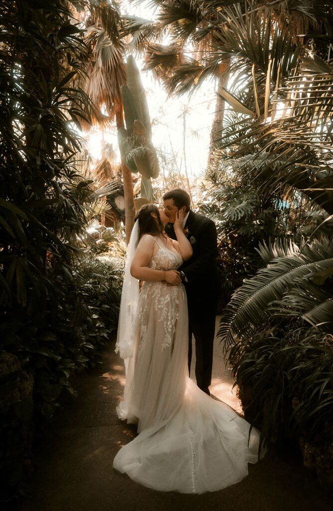 Couple kiss at Phipps Conservatory during their wedding