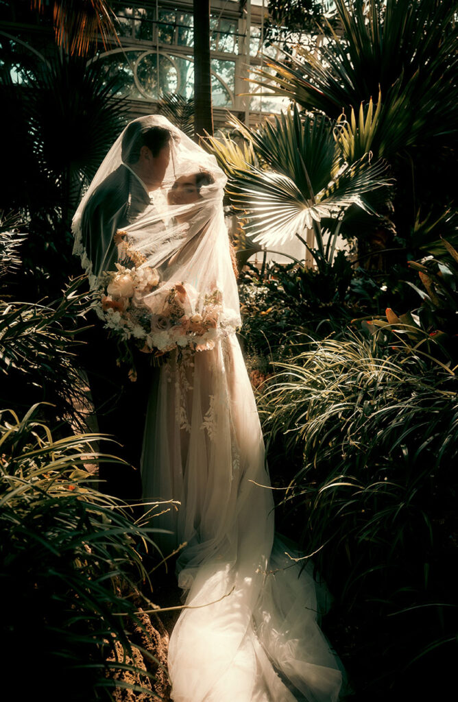 Couple kiss at Phipps Conservatory during their wedding