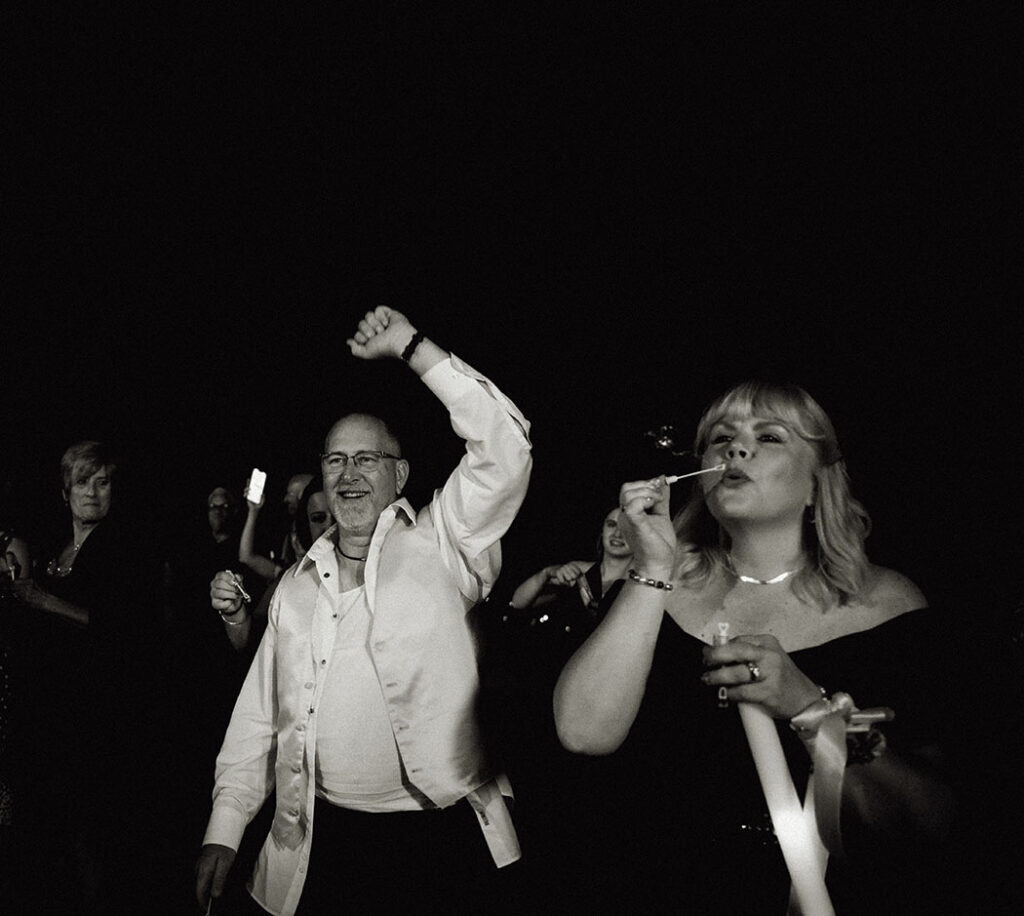 Guests blow bubbles for the bride and groom