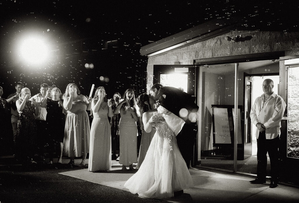 Bride and Groom kiss as they have a bubble exist with all their guests