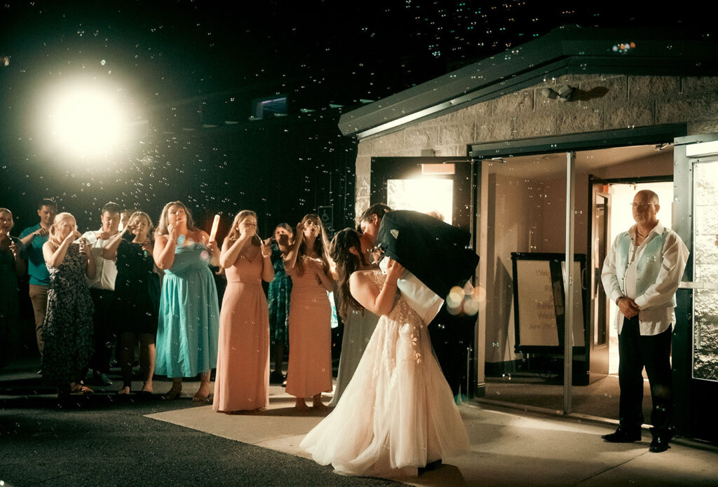 Bride and Groom kiss as they have a bubble exist with all their guests