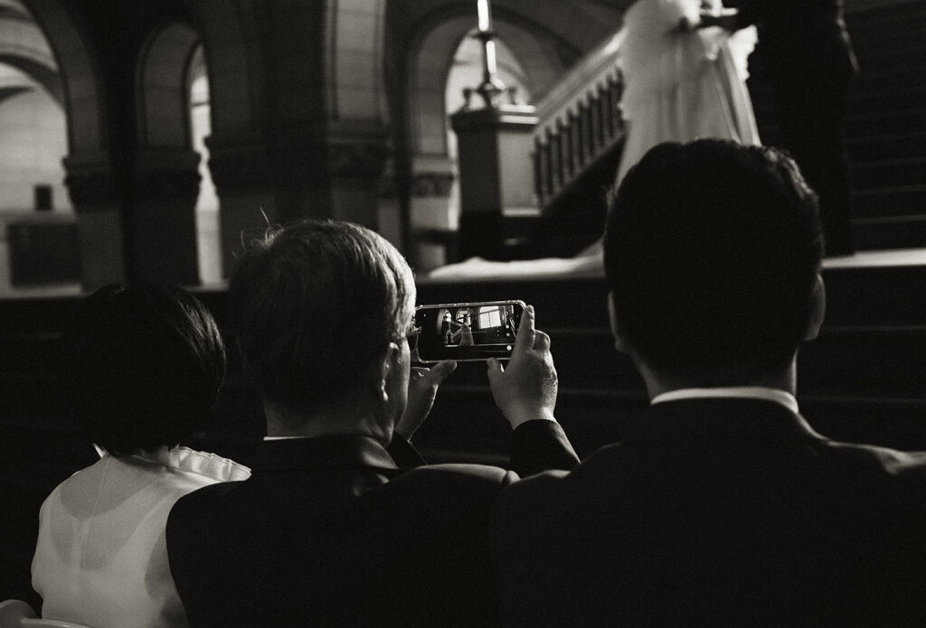 Guest takes photo of bride and groom while they get married in Allegheny County Courthouse