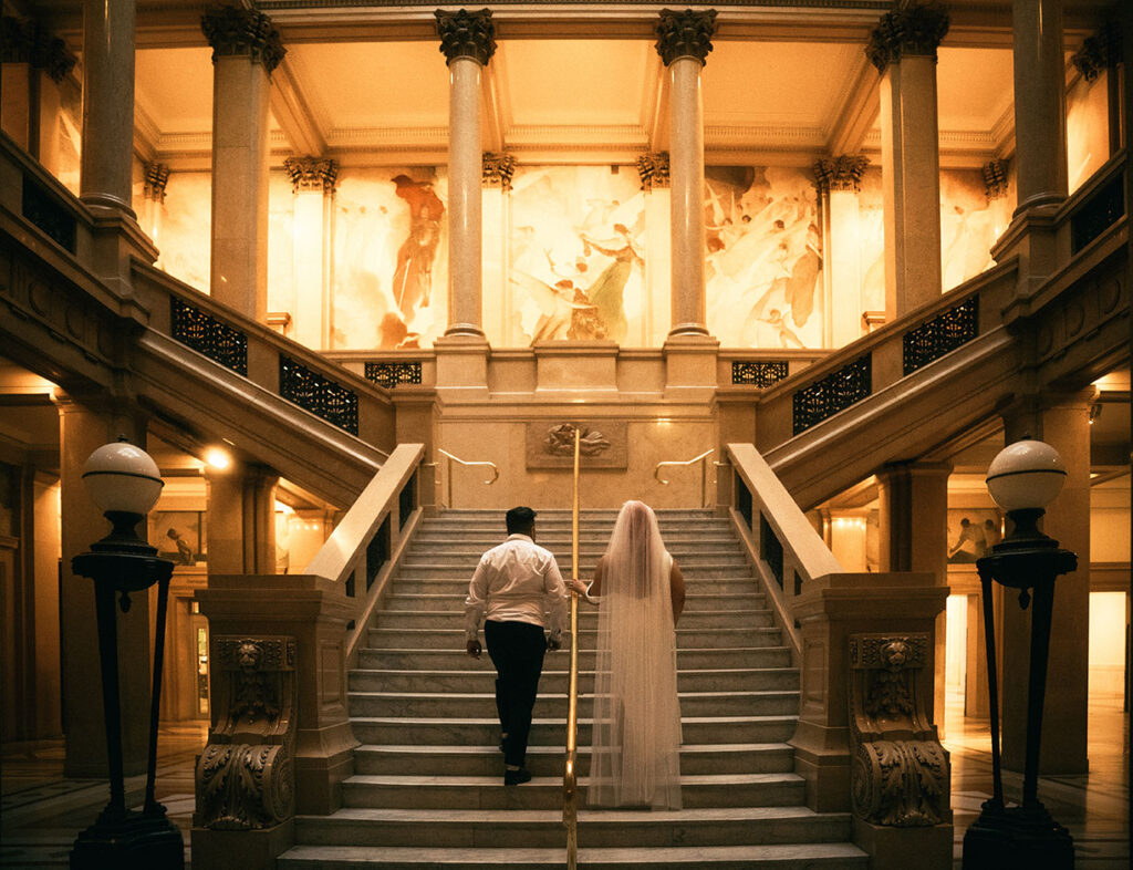 Bride and Groom walk up the grand staircase of Carnegie museum of art in Pittsburgh