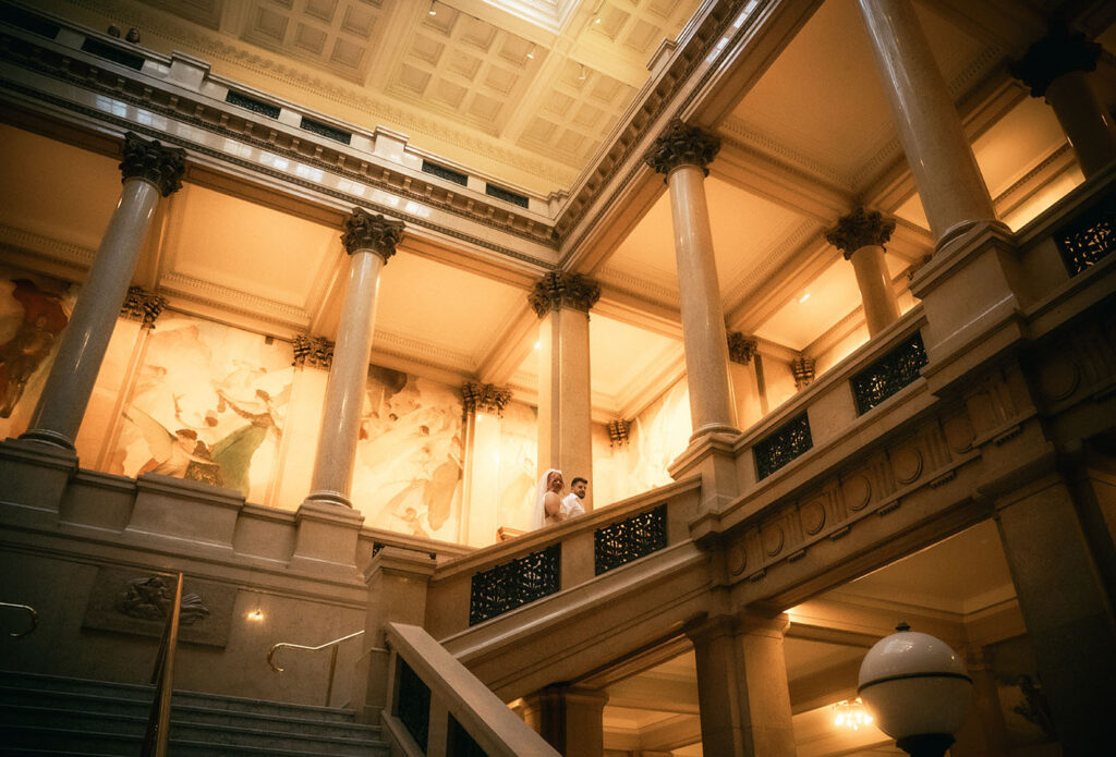 Bride and Groom walk up the grand staircase of Carnegie museum of art in Pittsburgh